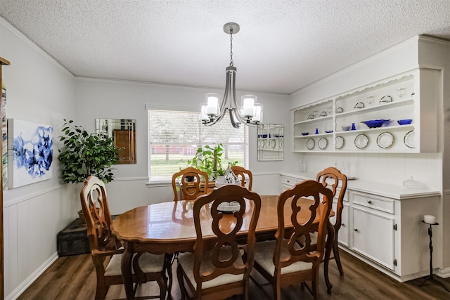 dining area featuring dark wood-style floors, a textured ceiling, and crown molding