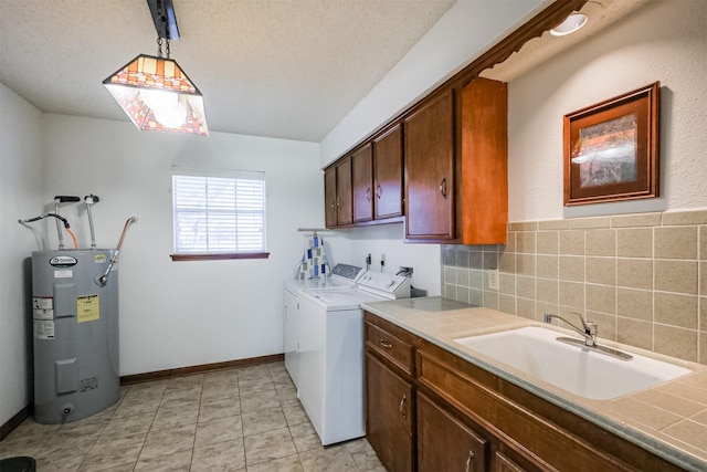 laundry room with washing machine and clothes dryer, electric water heater, cabinet space, a textured ceiling, and a sink