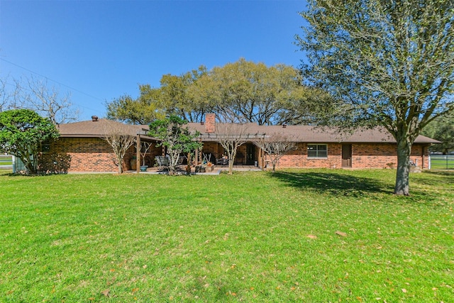 back of house featuring a yard, a patio, and brick siding