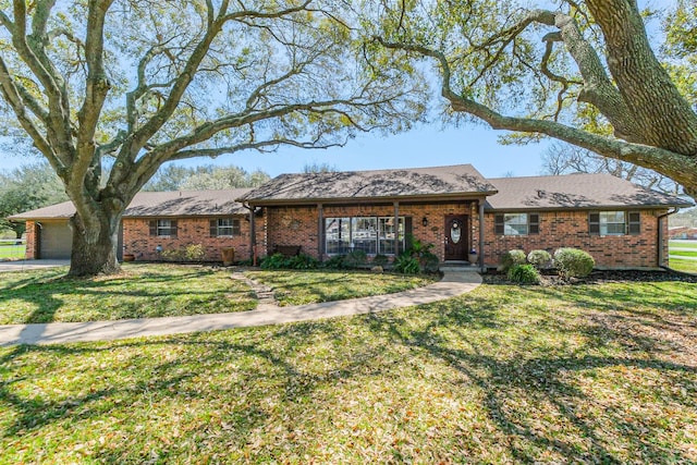 ranch-style house featuring a garage, brick siding, and a front lawn