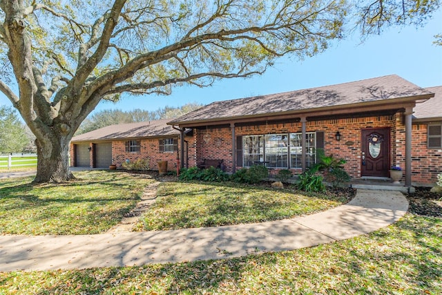 ranch-style home with a front lawn, an attached garage, and brick siding