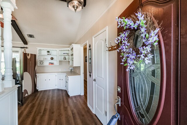 foyer entrance featuring visible vents, dark wood-type flooring, and ornamental molding