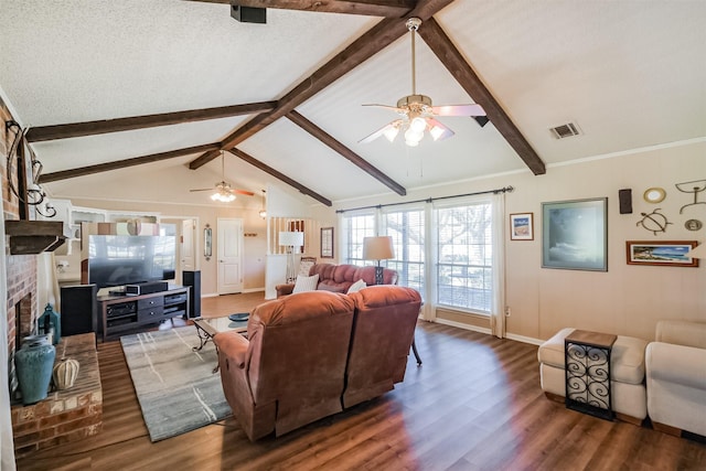 living room with visible vents, a brick fireplace, lofted ceiling with beams, wood finished floors, and a textured ceiling