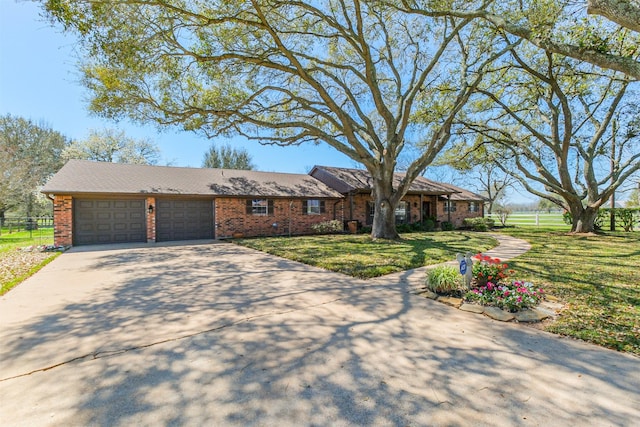 view of front of property with driveway, a front lawn, brick siding, and an attached garage