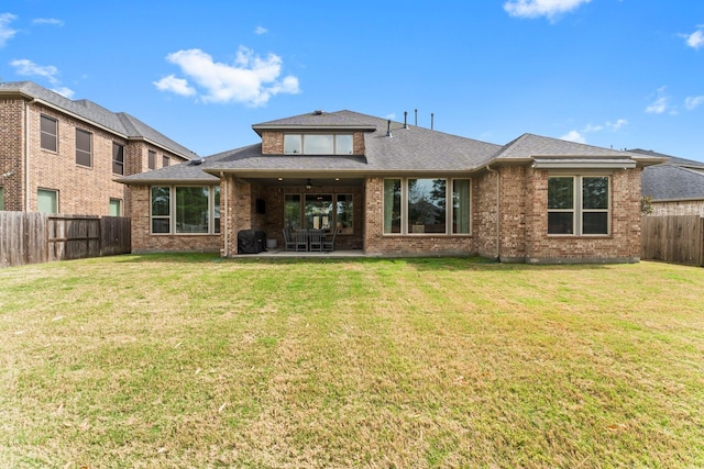 back of house with a ceiling fan, a patio, a yard, and a fenced backyard