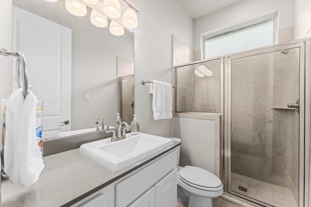 bathroom featuring a shower stall, toilet, and vanity