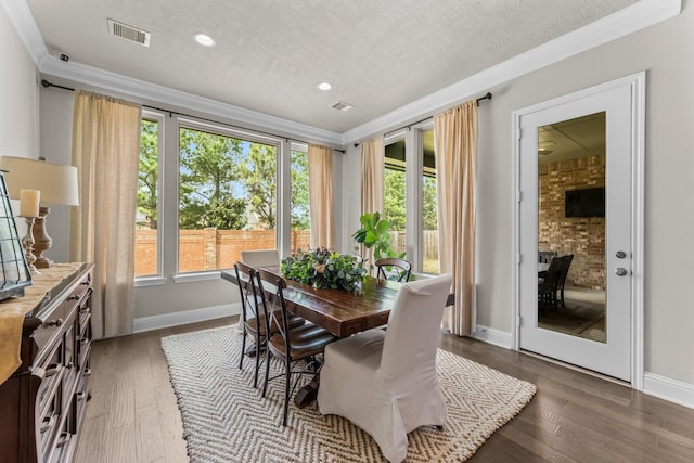 dining room with crown molding, plenty of natural light, visible vents, and a textured ceiling