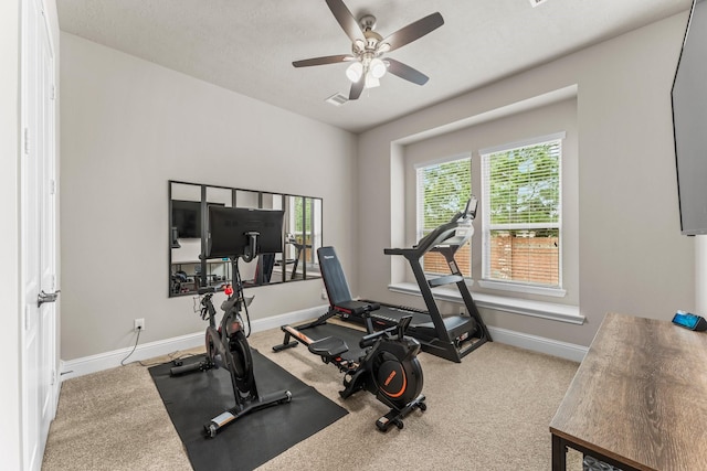 workout area with baseboards, a ceiling fan, and carpet flooring