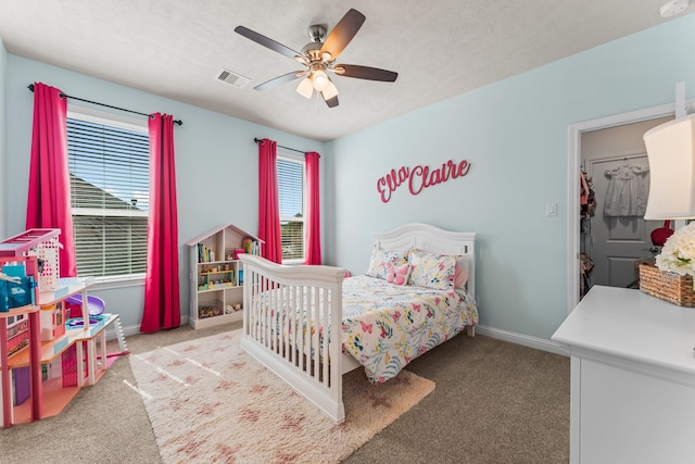 carpeted bedroom featuring a textured ceiling, baseboards, visible vents, and ceiling fan