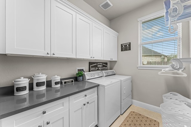 clothes washing area featuring visible vents, washer and dryer, cabinet space, light tile patterned floors, and baseboards