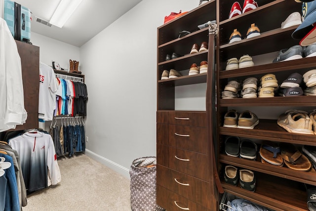 spacious closet featuring carpet flooring, lofted ceiling, and visible vents