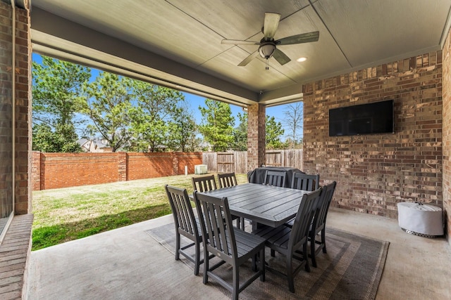 view of patio with outdoor dining area, a fenced backyard, and a ceiling fan