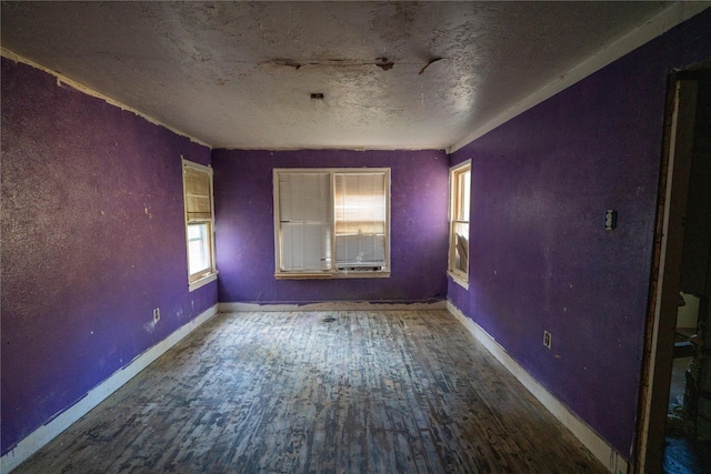 empty room with baseboards and wood finished floors