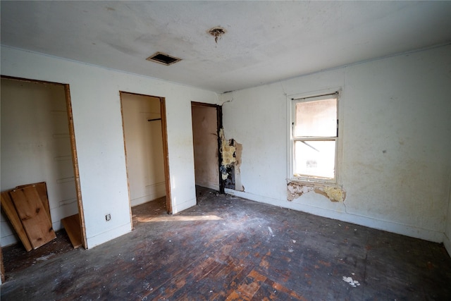 unfurnished bedroom with visible vents and multiple closets