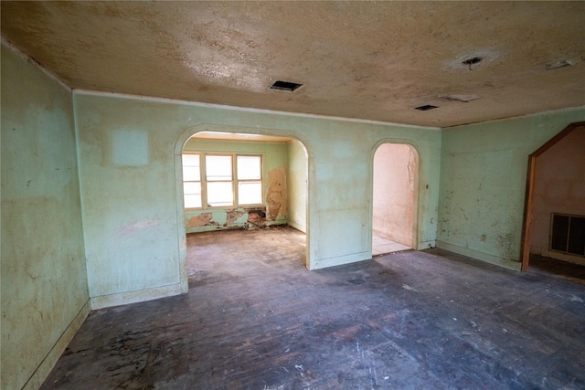 empty room featuring visible vents and arched walkways