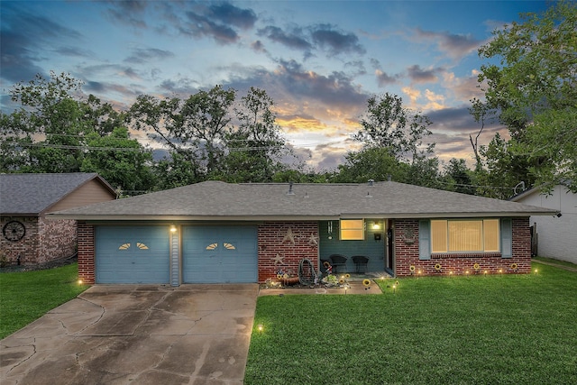 ranch-style house with a lawn, concrete driveway, an attached garage, a shingled roof, and brick siding