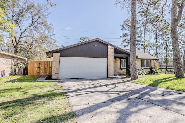 mid-century inspired home featuring brick siding, a front lawn, a garage, and fence