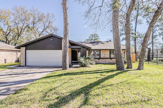 view of front of property with fence, concrete driveway, a front lawn, a garage, and brick siding