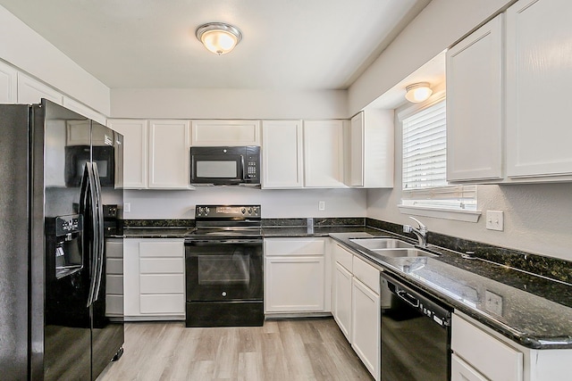 kitchen featuring a sink, black appliances, white cabinets, and light wood finished floors