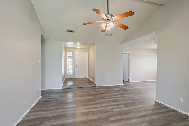 spare room with visible vents, baseboards, lofted ceiling, wood finished floors, and a ceiling fan