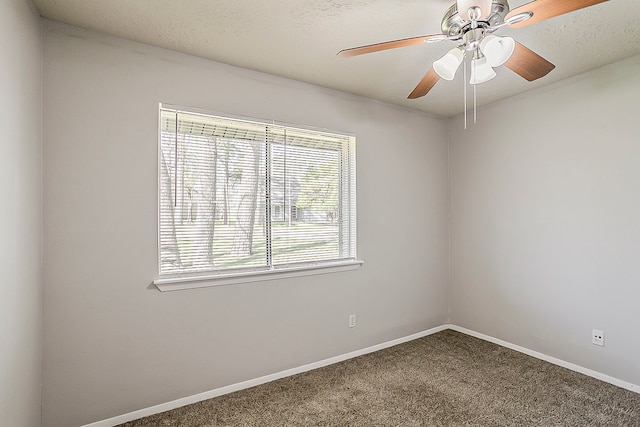 empty room with carpet flooring, a ceiling fan, and baseboards