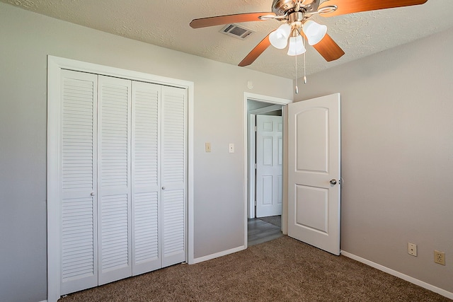 unfurnished bedroom with baseboards, carpet, a closet, and a textured ceiling