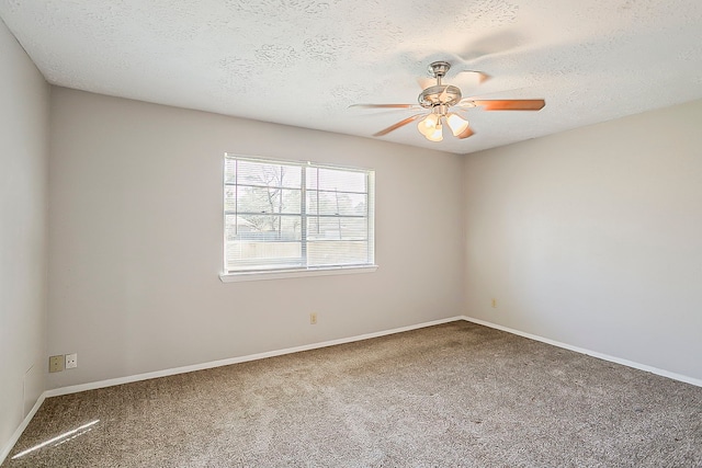 carpeted spare room with baseboards, a textured ceiling, and a ceiling fan