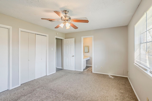 unfurnished bedroom with carpet flooring, a ceiling fan, baseboards, and a textured ceiling