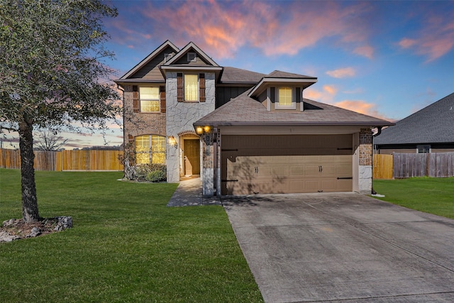 view of front facade featuring a front yard, concrete driveway, an attached garage, and fence