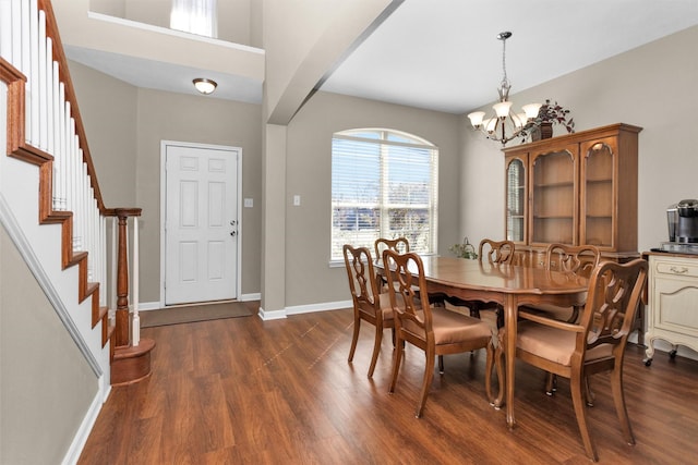 dining room with stairway, baseboards, arched walkways, and dark wood finished floors