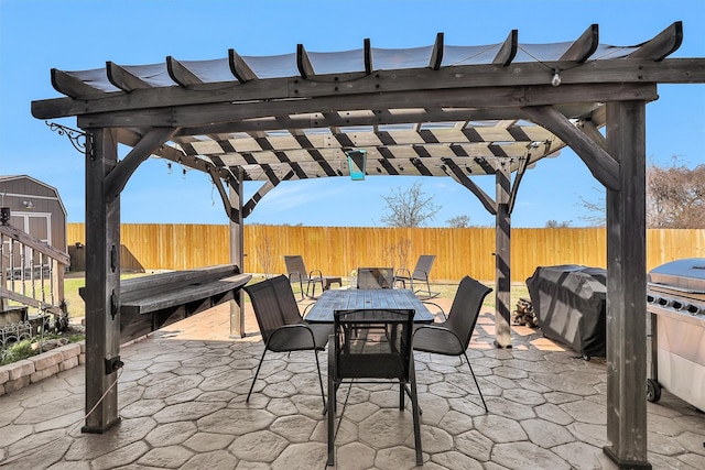 view of patio / terrace featuring a shed, a fenced backyard, an outdoor structure, outdoor dining space, and a pergola