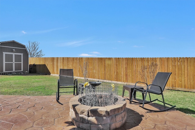 view of patio with an outdoor structure, a fire pit, a fenced backyard, and a shed