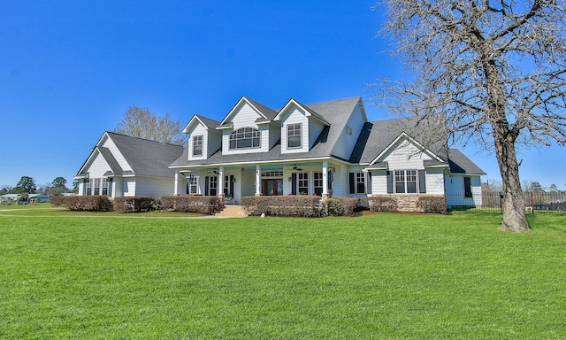 cape cod home with a ceiling fan, a porch, a front lawn, and fence