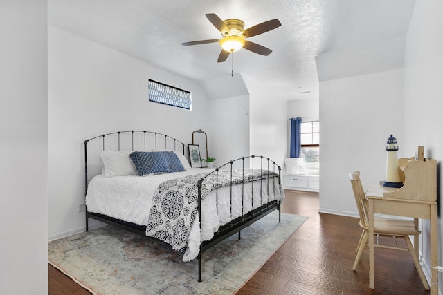 bedroom featuring baseboards, vaulted ceiling, wood finished floors, a textured ceiling, and a ceiling fan