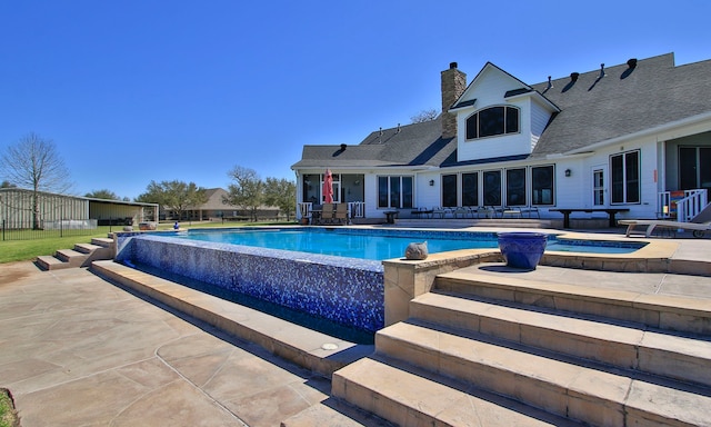 view of pool featuring a fenced in pool, a patio, and a hot tub