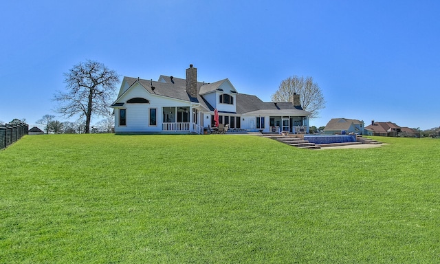 rear view of property with a chimney and a yard