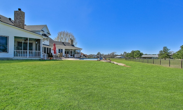 view of yard featuring a patio, fence, a fenced in pool, and a sunroom