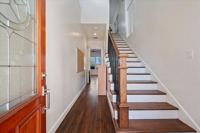 staircase featuring wood finished floors and baseboards