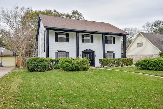 view of front facade featuring brick siding, roof with shingles, and a front lawn