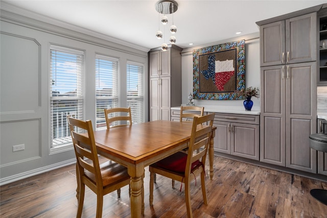 dining space featuring dark wood finished floors and crown molding