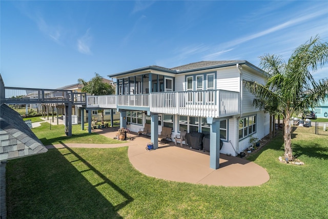 back of property featuring a lawn, a patio, and a sunroom