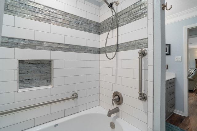 full bath featuring crown molding, baseboards, washtub / shower combination, wood finished floors, and vanity