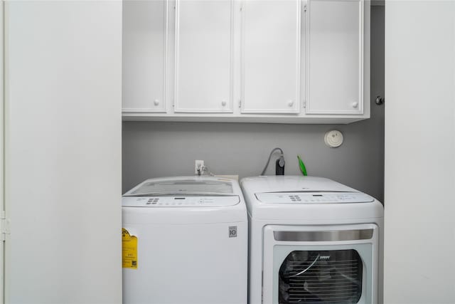 washroom featuring washer and dryer and cabinet space