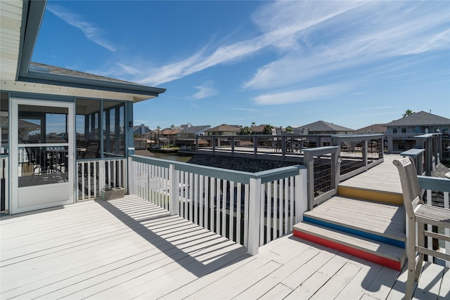 wooden terrace featuring a residential view and a sunroom