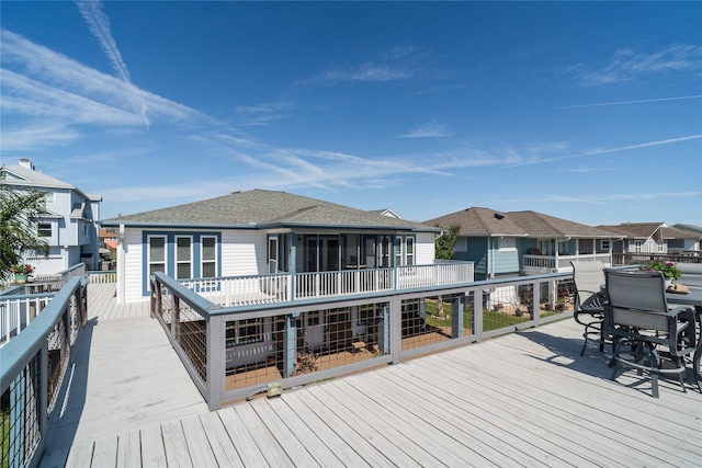 deck with outdoor dining area, a residential view, and a sunroom