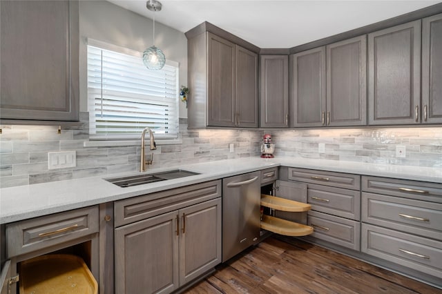 kitchen with a sink, backsplash, gray cabinetry, and light countertops