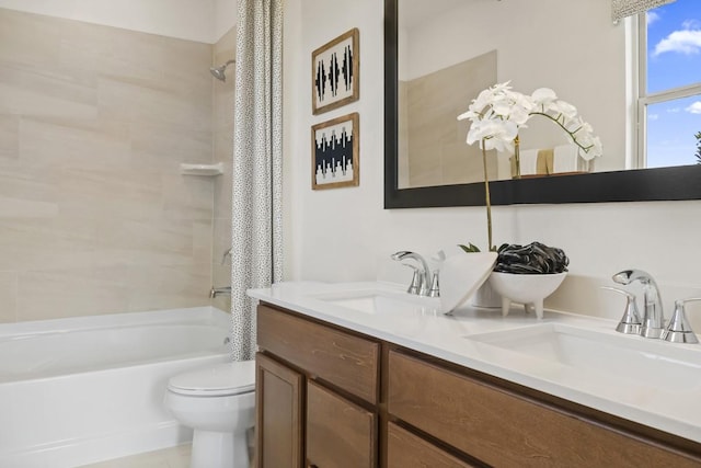 bathroom featuring a sink, toilet, double vanity, and shower / tub combo