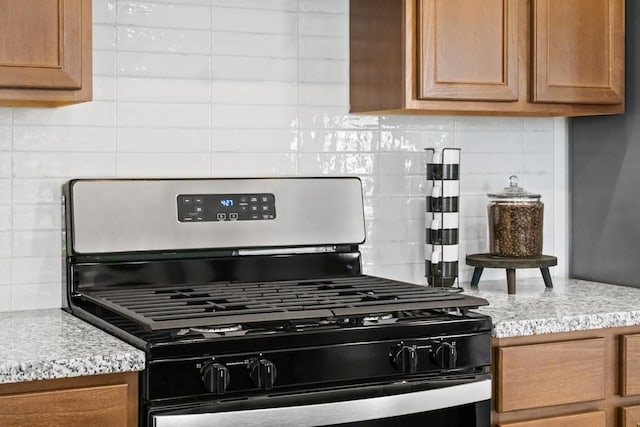 kitchen featuring decorative backsplash, brown cabinetry, and gas stove