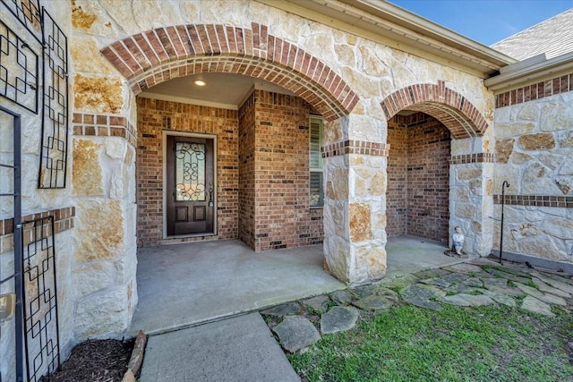 property entrance featuring brick siding and stone siding