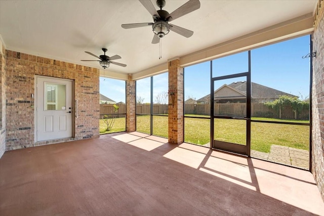 unfurnished sunroom featuring a ceiling fan